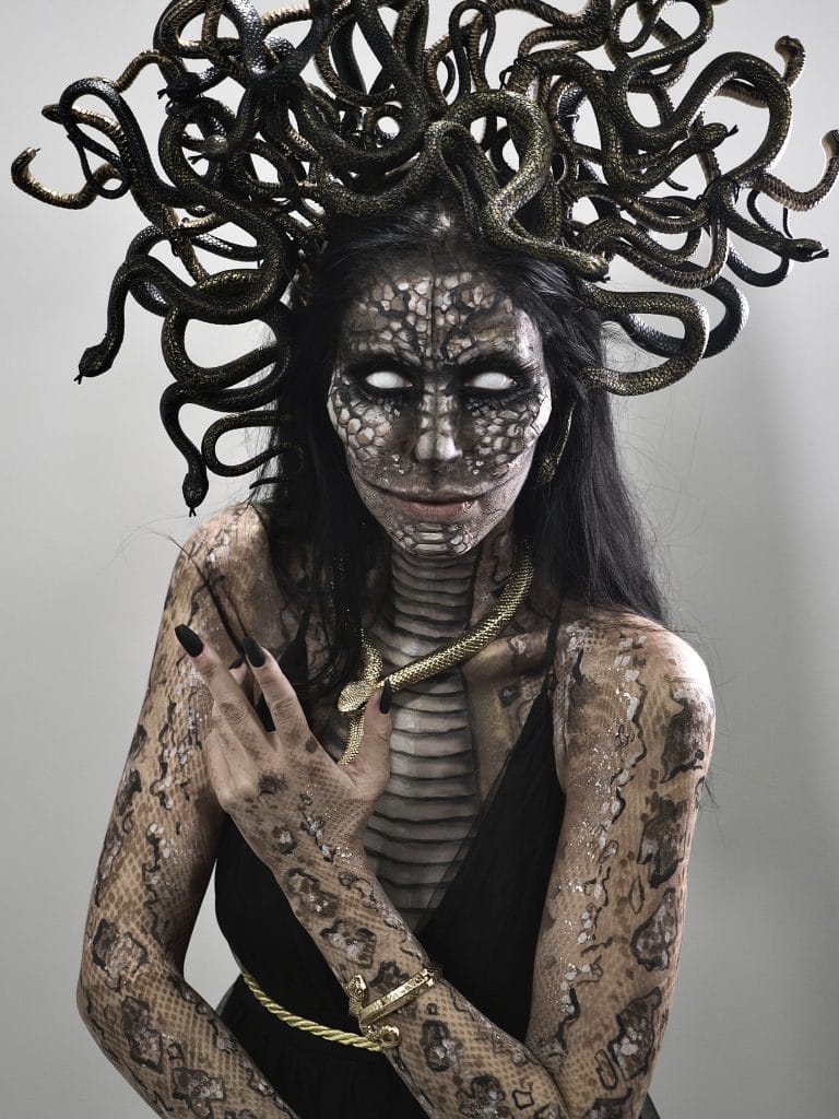 A woman wearing a medusa costume with snakes on her head.