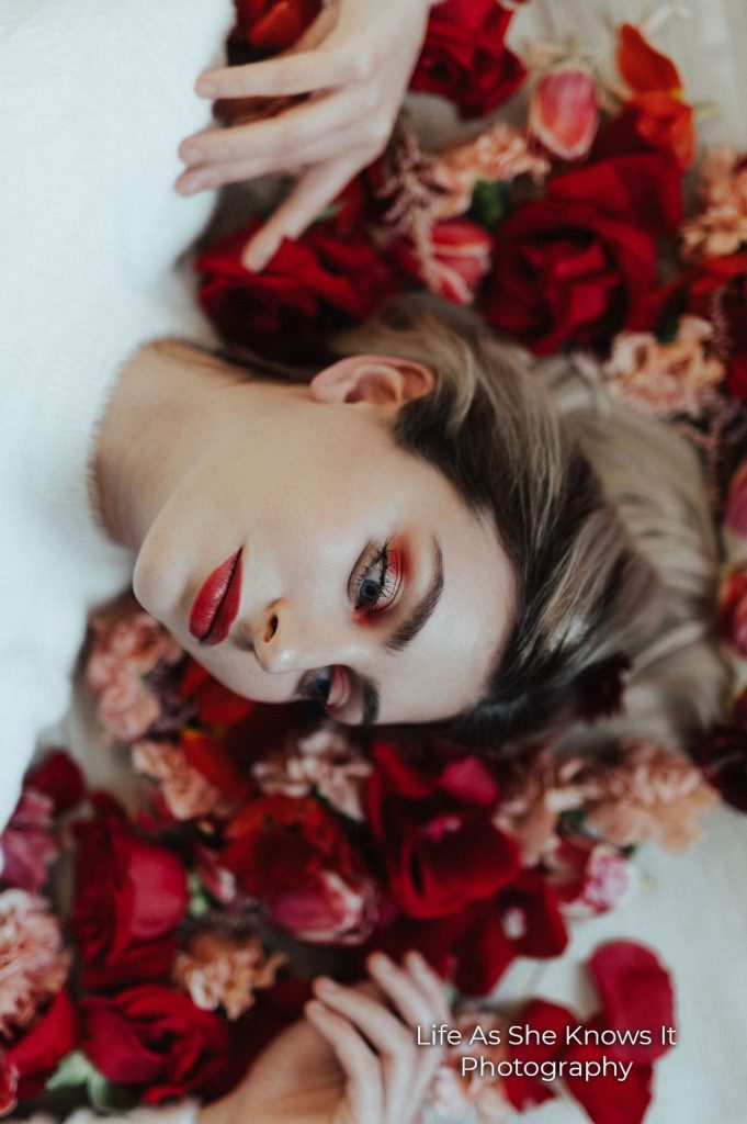 A woman laying on a bed of roses.