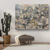 An abstract painting hangs above a cactus in a living room.