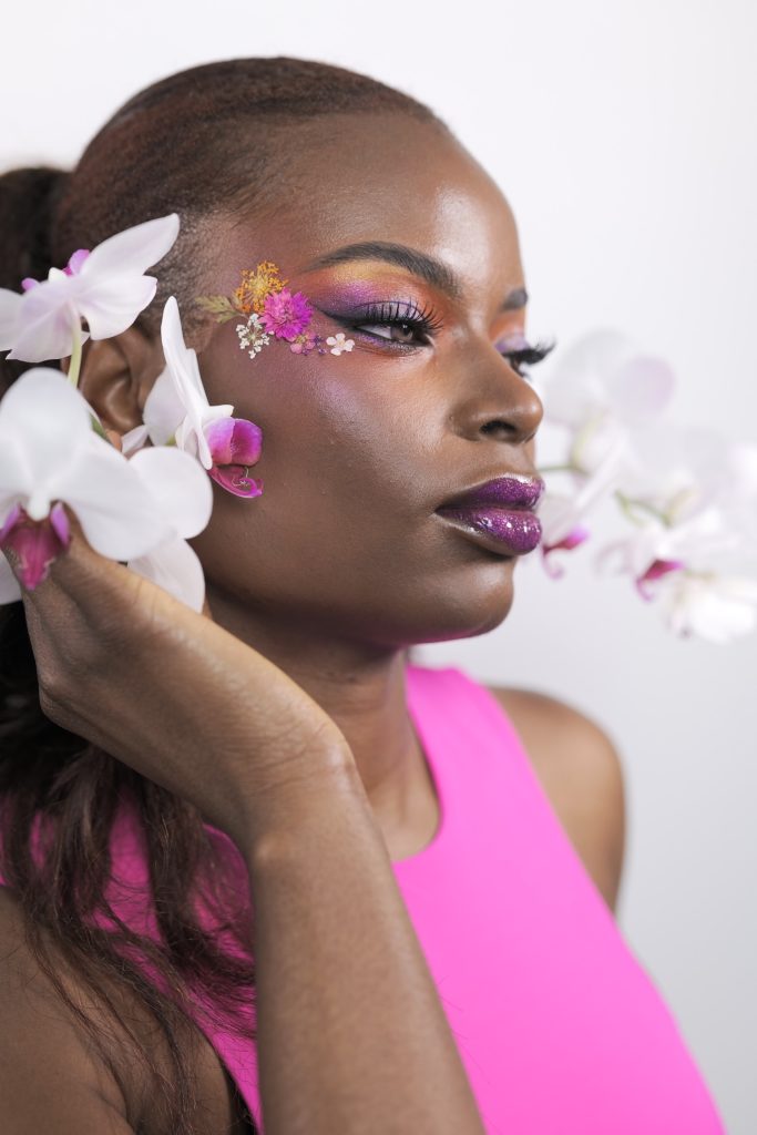 A black woman with flowers on her face.