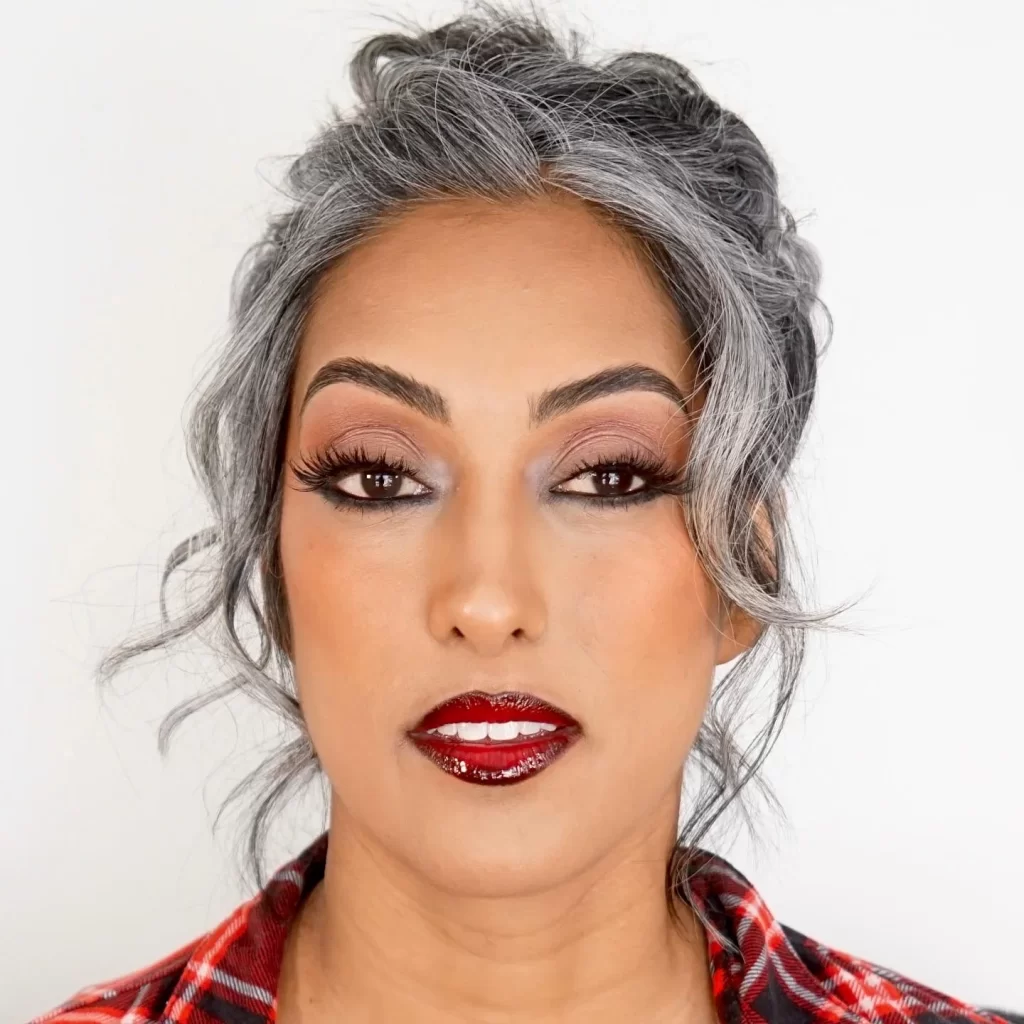 A woman with gray hair wearing a plaid shirt.