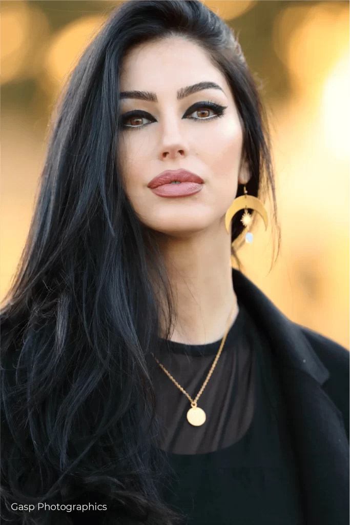 A woman with long black hair posing for a photo.